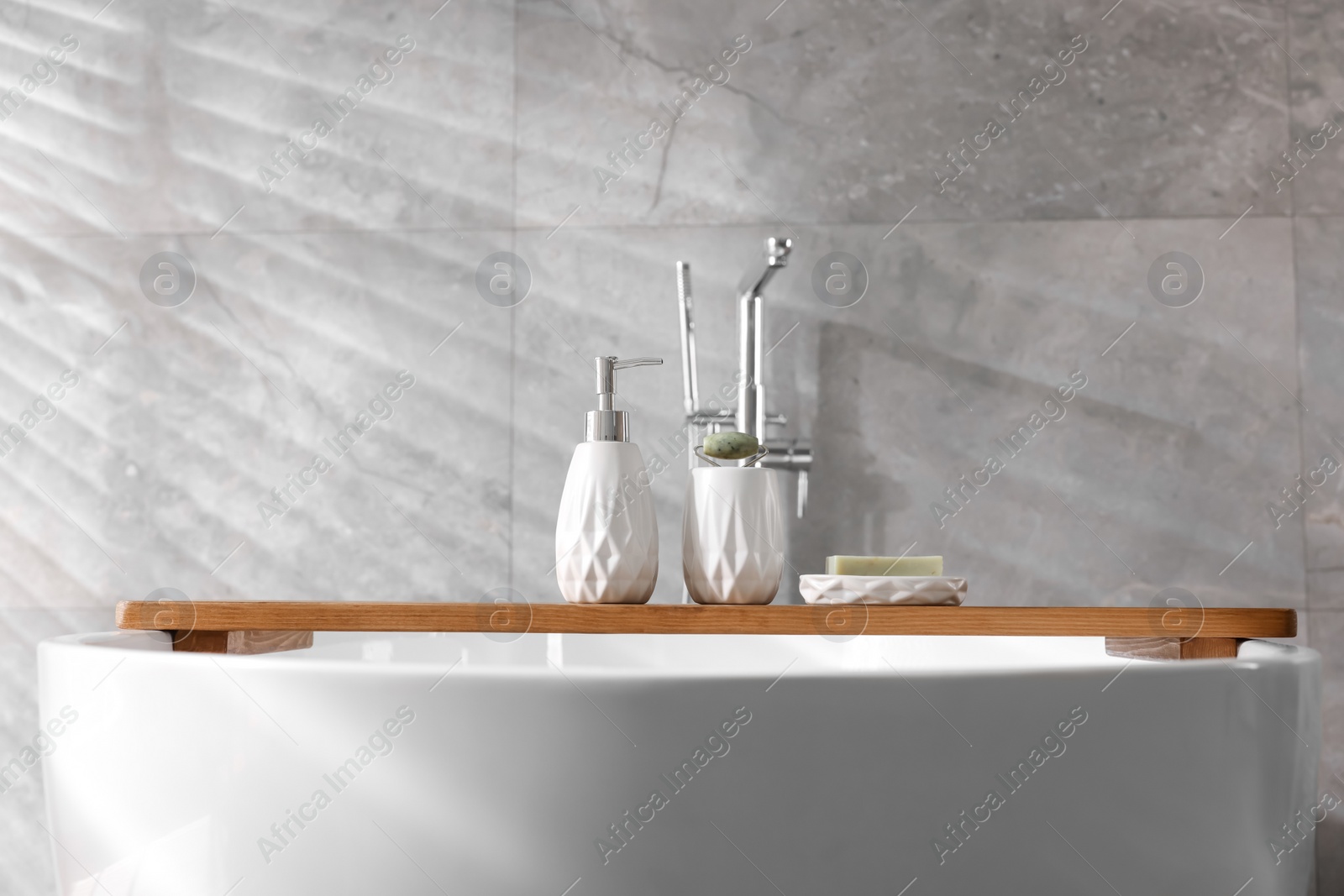 Photo of Different personal care products and accessories on bath tub in bathroom