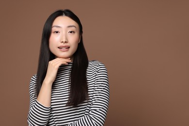 Photo of Portrait of smiling woman on brown background. Space for text