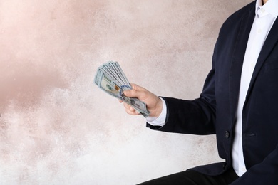 Photo of Businessman in suit holding money on color background