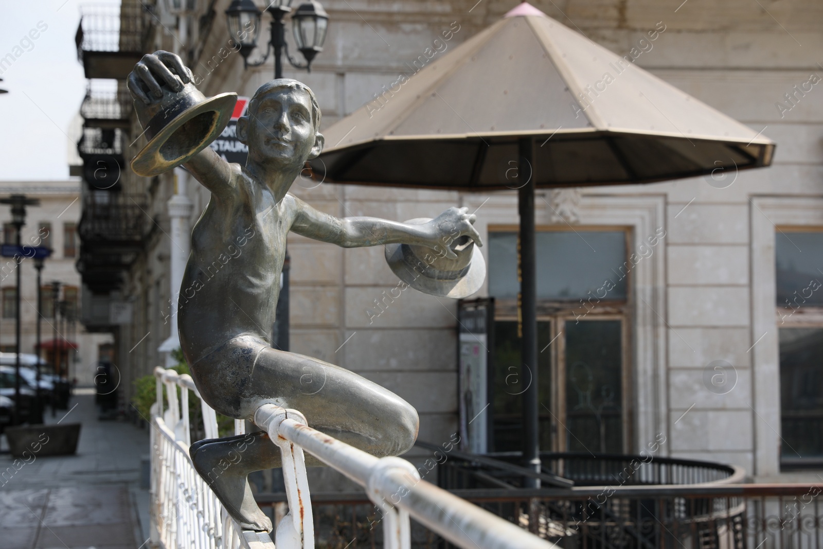 Photo of Kutaisi, Georgia - September 2, 2022: Sculpture of boy with hats on white bridge