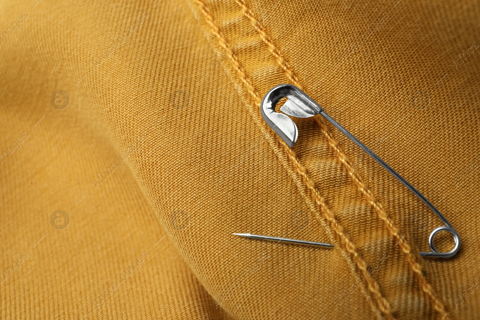 Photo of Closeup view of metal safety pin on clothing