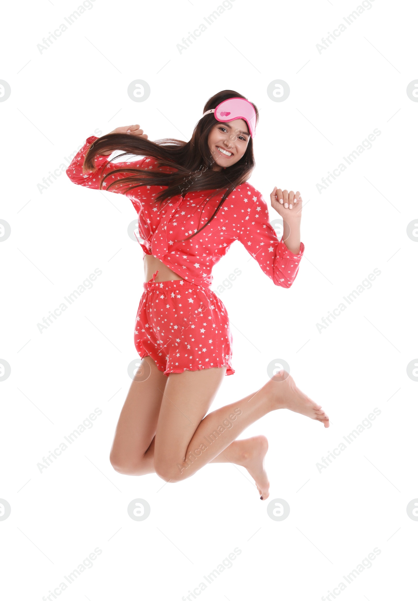 Photo of Beautiful woman with sleeping mask jumping on white background. Bedtime