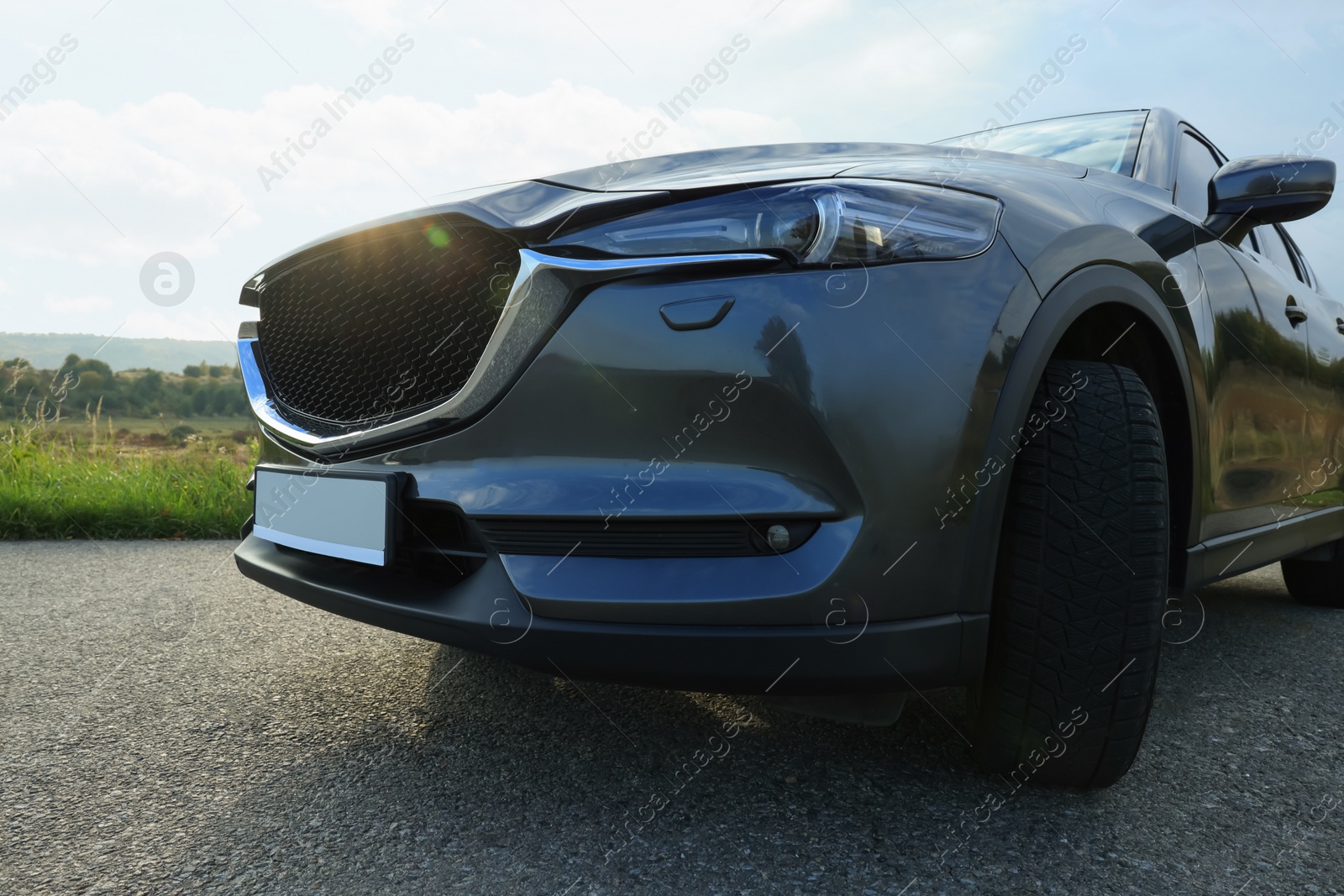 Photo of Black modern car parked on asphalt road, closeup