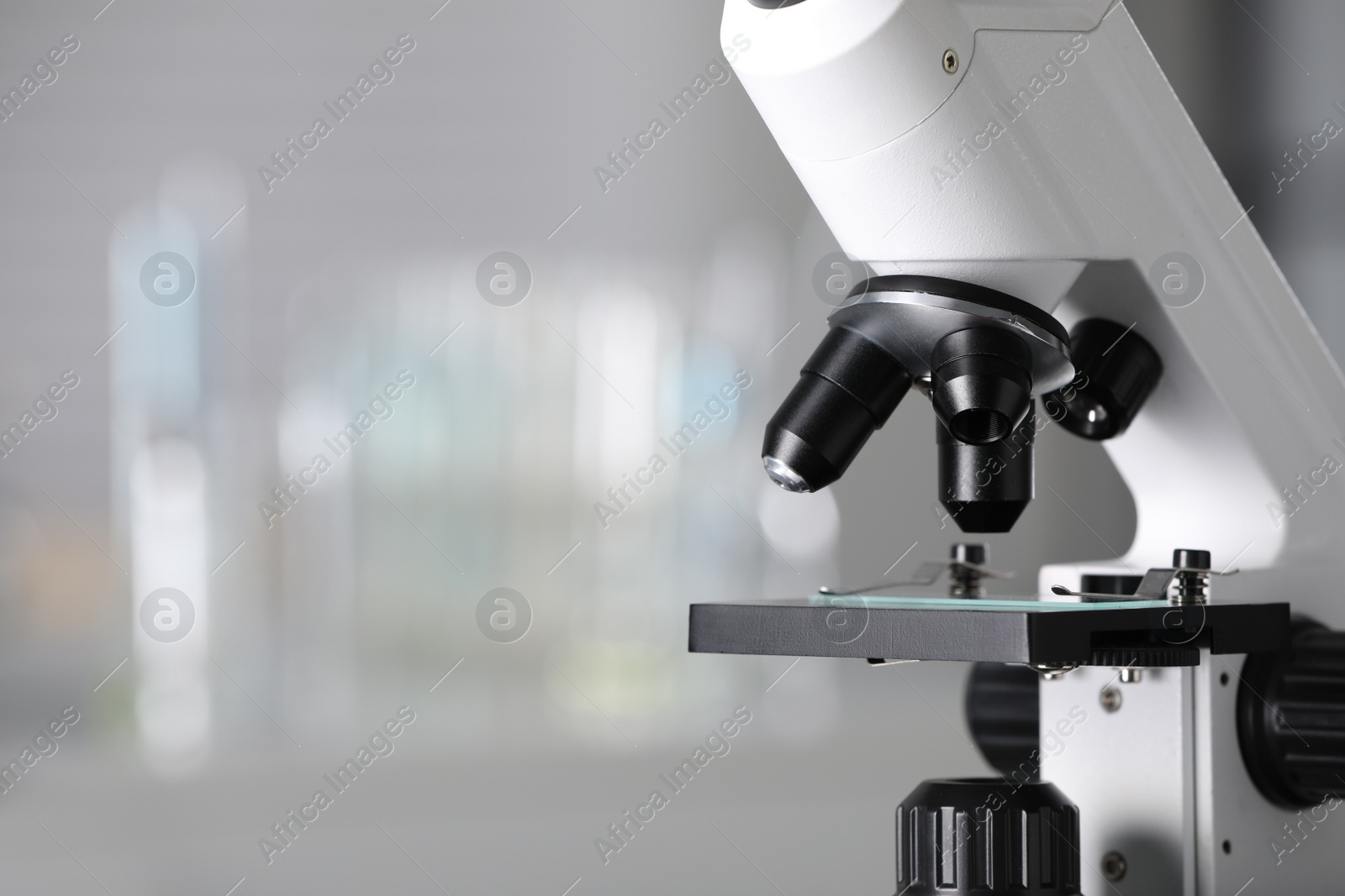 Photo of Modern medical microscope on blurred background, closeup with space for text. Laboratory equipment