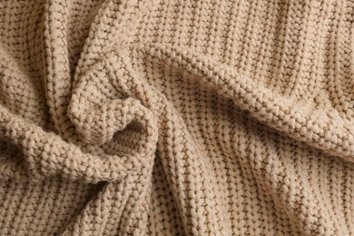 Photo of Beautiful beige knitted fabric as background, top view