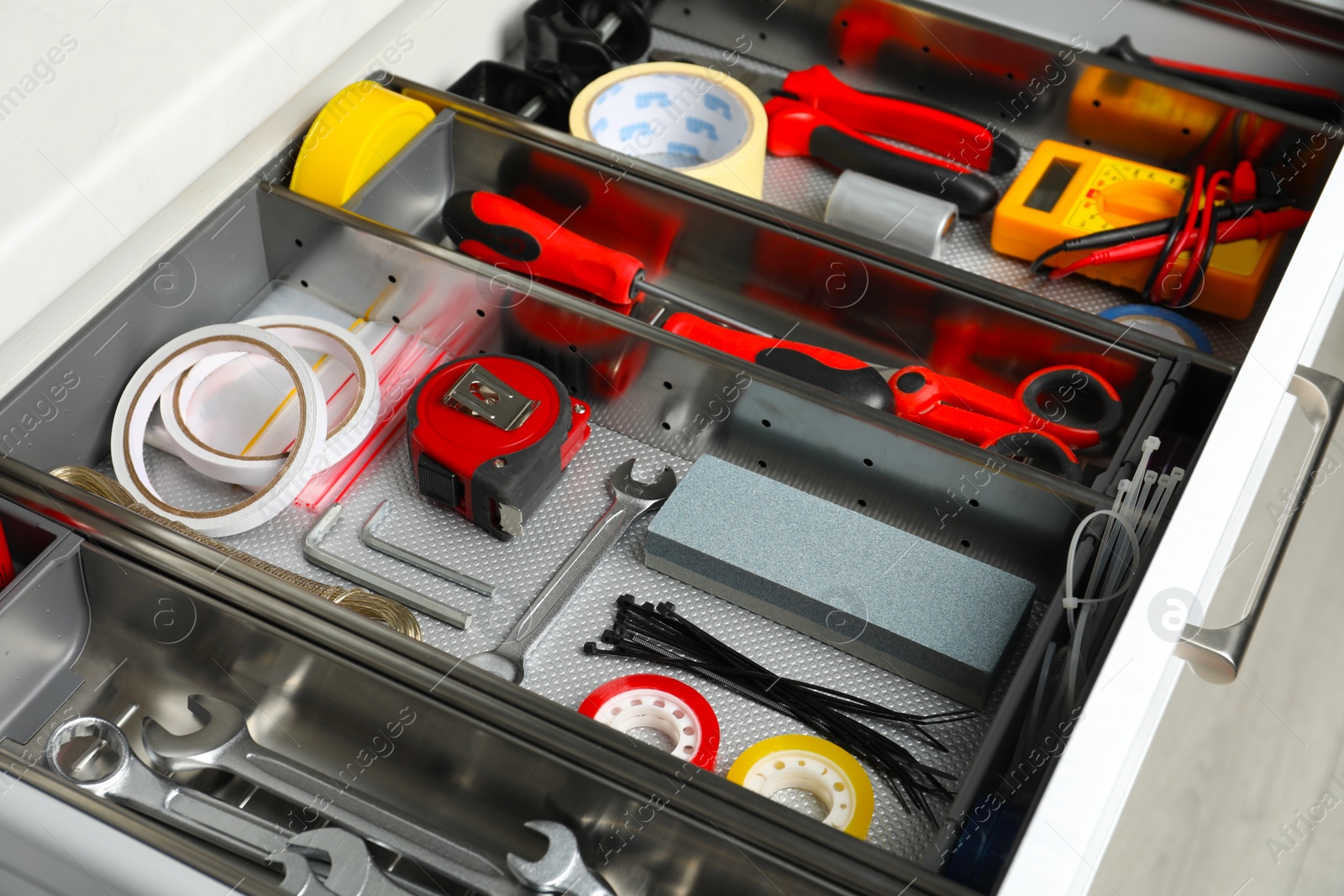 Photo of Set of instruments in open desk drawer indoors, closeup