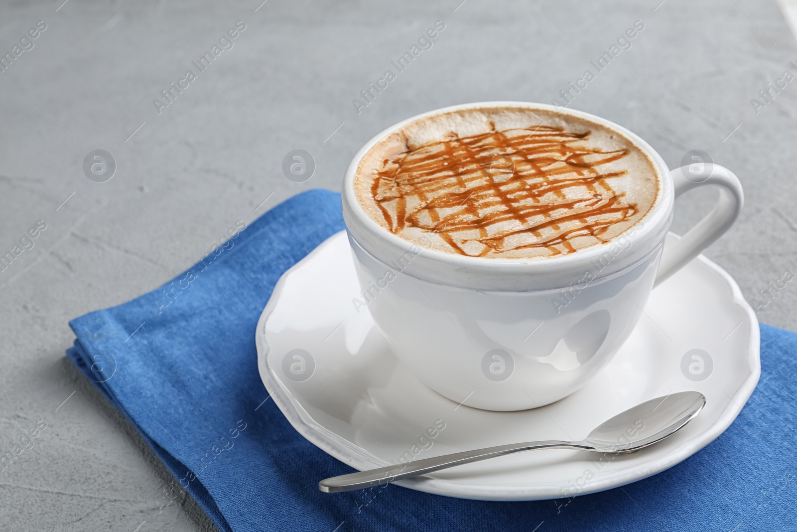 Photo of Cup of tasty caramel macchiato on table. Space for text