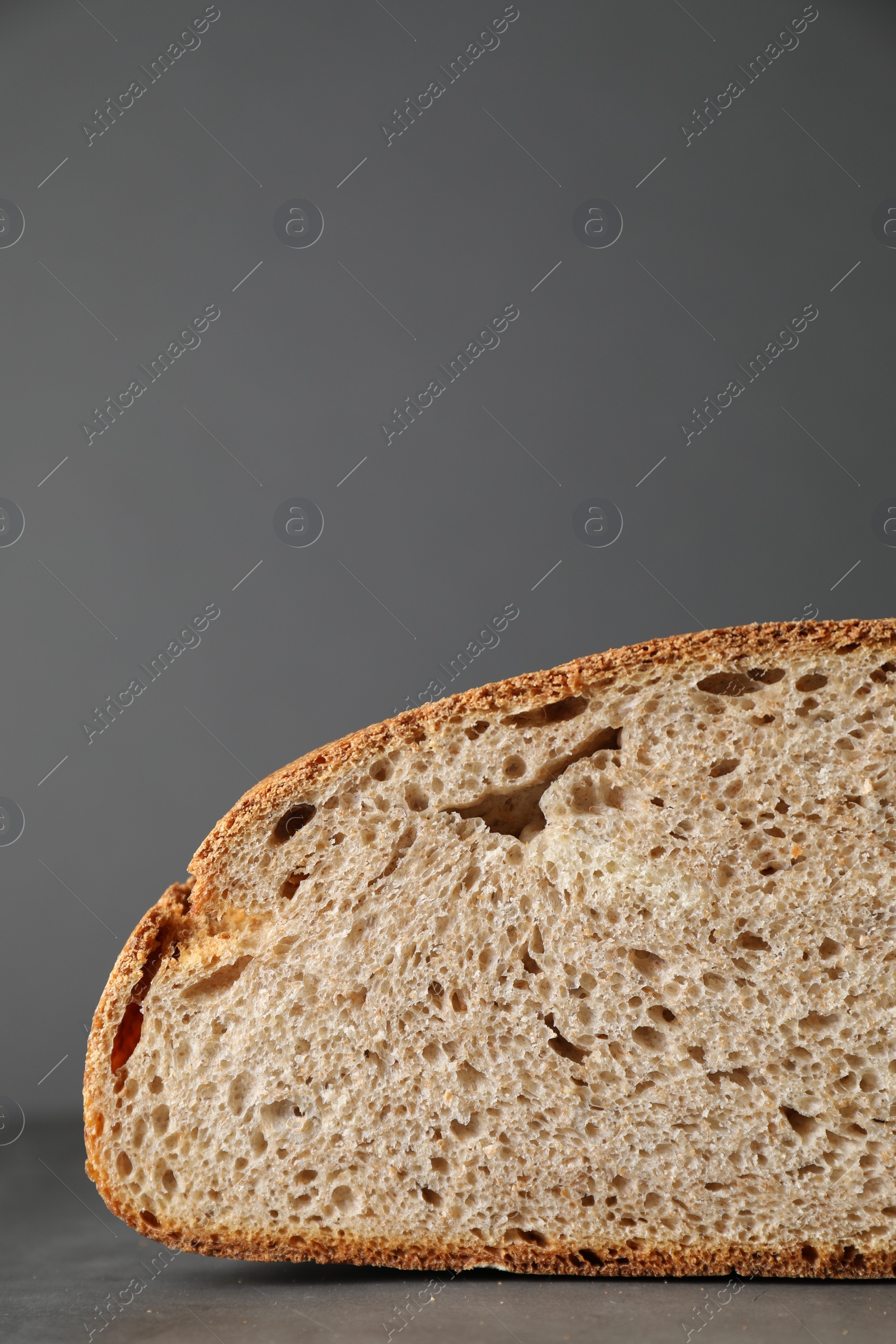 Photo of Piece of freshly baked sourdough bread on grey table