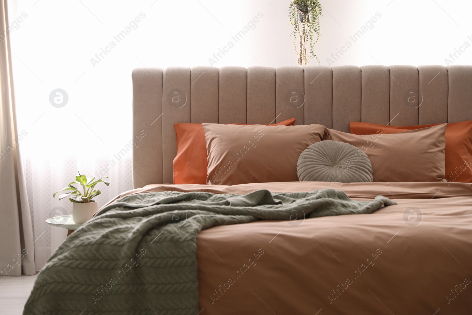 Photo of Bed with stylish cotton linens in room