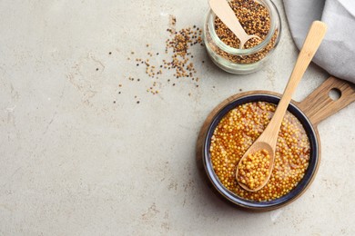 Photo of Whole grain mustard and dry seeds on white table, flat lay. Space for text