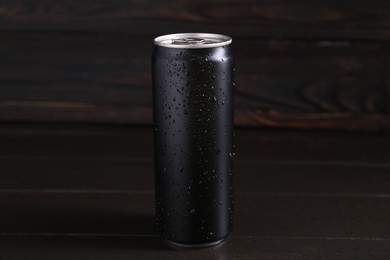 Photo of Energy drink in wet can on dark wooden table