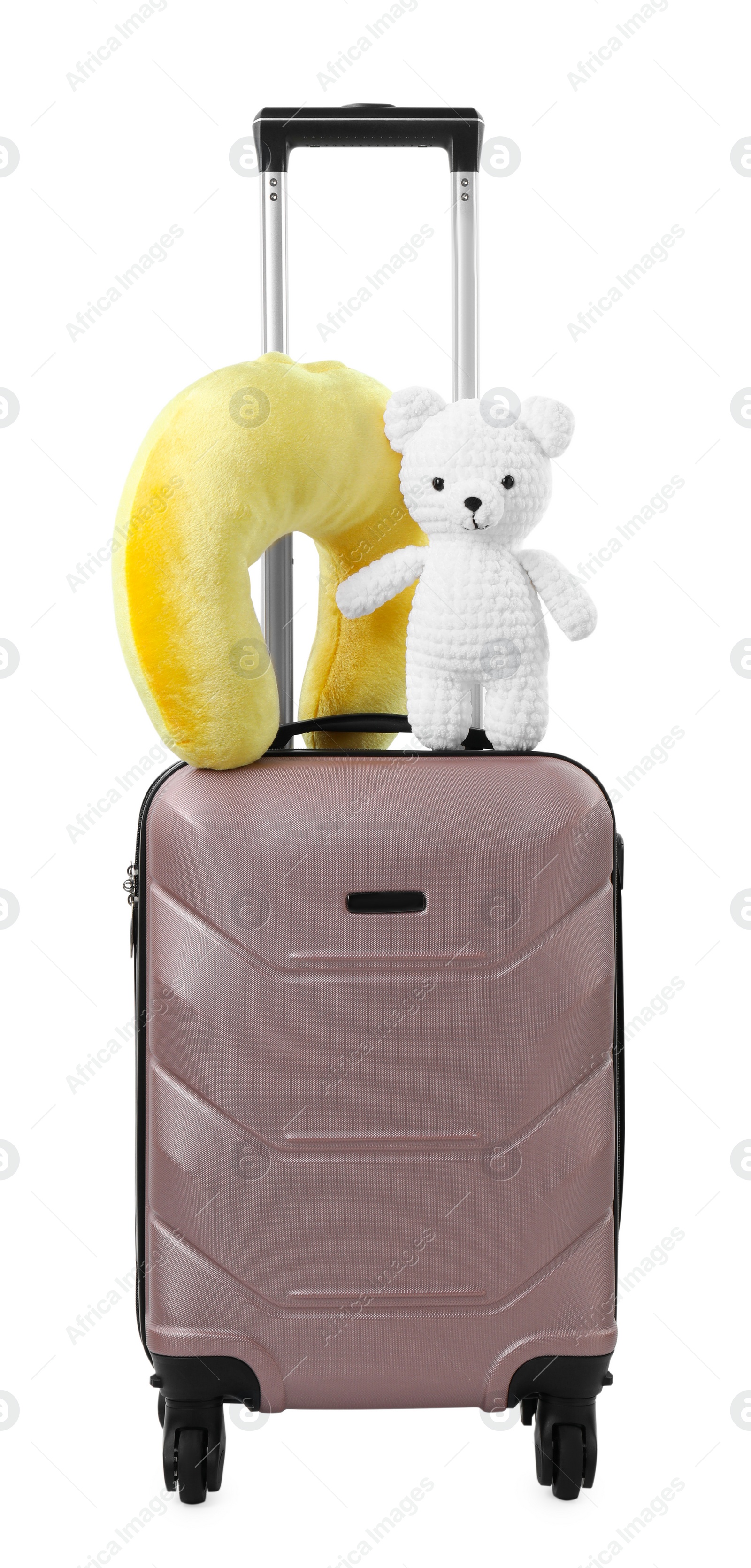 Photo of Soft travel pillow and toy bear on suitcase isolated on white