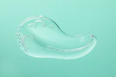 Photo of Sample of cleansing gel on turquoise background, top view. Cosmetic product
