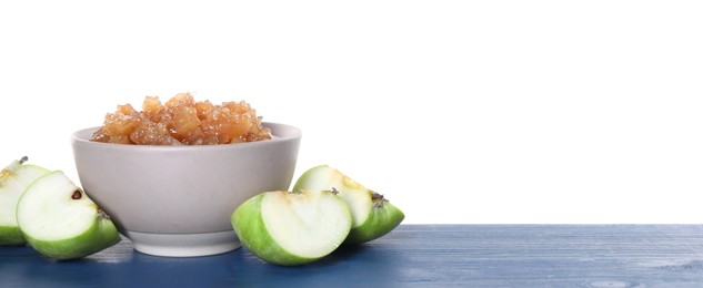 Bowl with delicious jam and pieces of apple on blue wooden table against white background