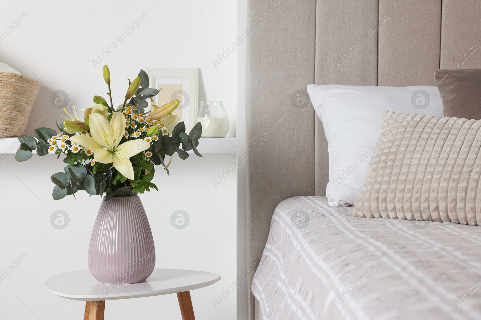 Photo of Bouquet of beautiful flowers on white table in bedroom