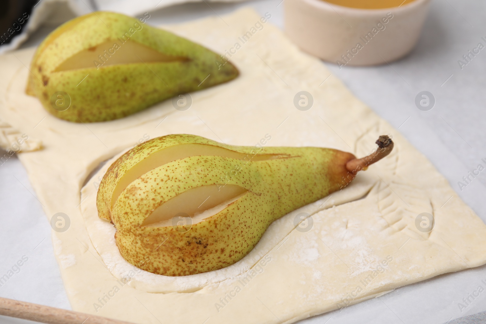 Photo of Raw dough with fresh pears on white table, closeup