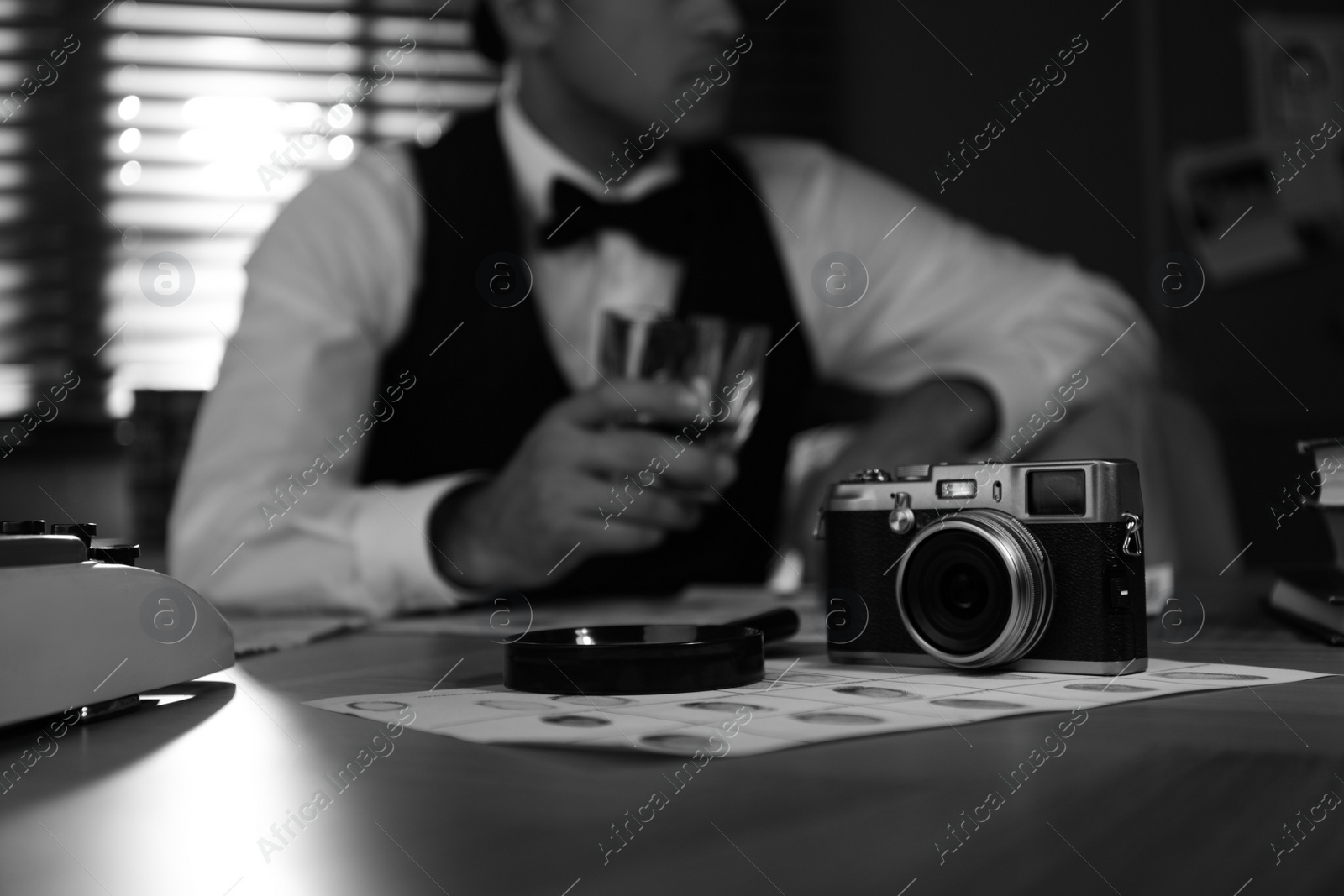 Photo of Detective's accessories on table in office, black and white effect
