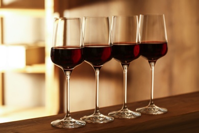 Photo of Glasses of red wine in cellar. Expensive drink