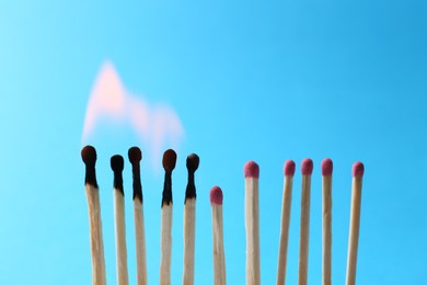 Burning and whole matches on light blue background. Space for text