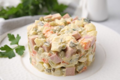 Photo of Tasty Olivier salad with boiled sausage on table, closeup