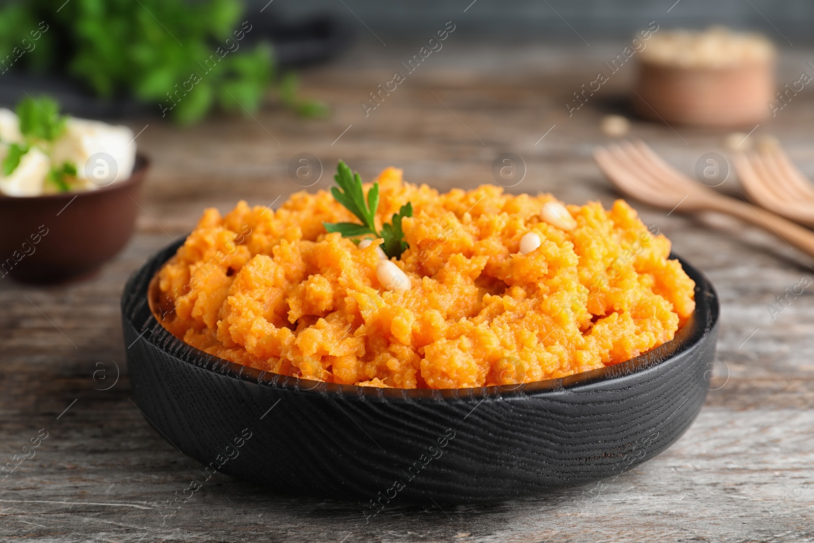 Photo of Plate with mashed sweet potatoes on wooden table