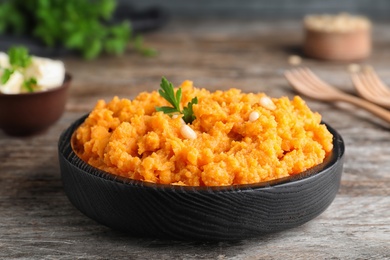 Plate with mashed sweet potatoes on wooden table