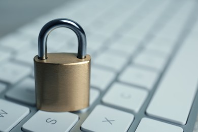 Photo of Metal padlock on computer keyboard, space for text. Cyber security concept