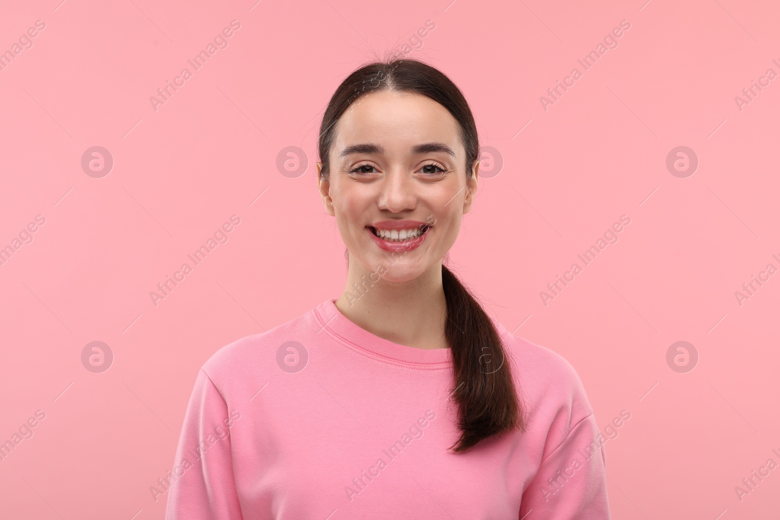 Photo of Beautiful woman with clean teeth smiling on pink background