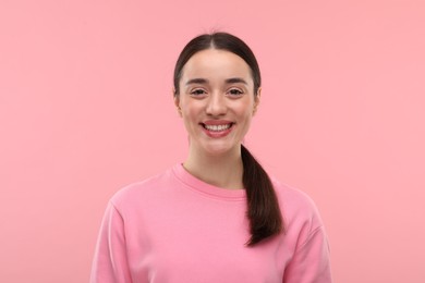 Beautiful woman with clean teeth smiling on pink background