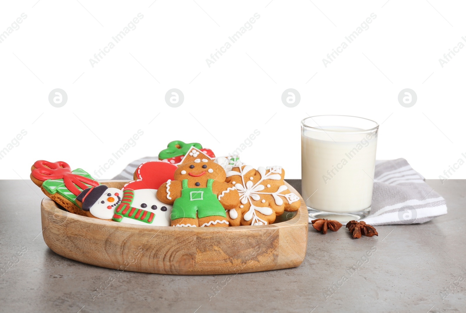 Photo of Tasty Christmas cookies near glass of milk on table against white background