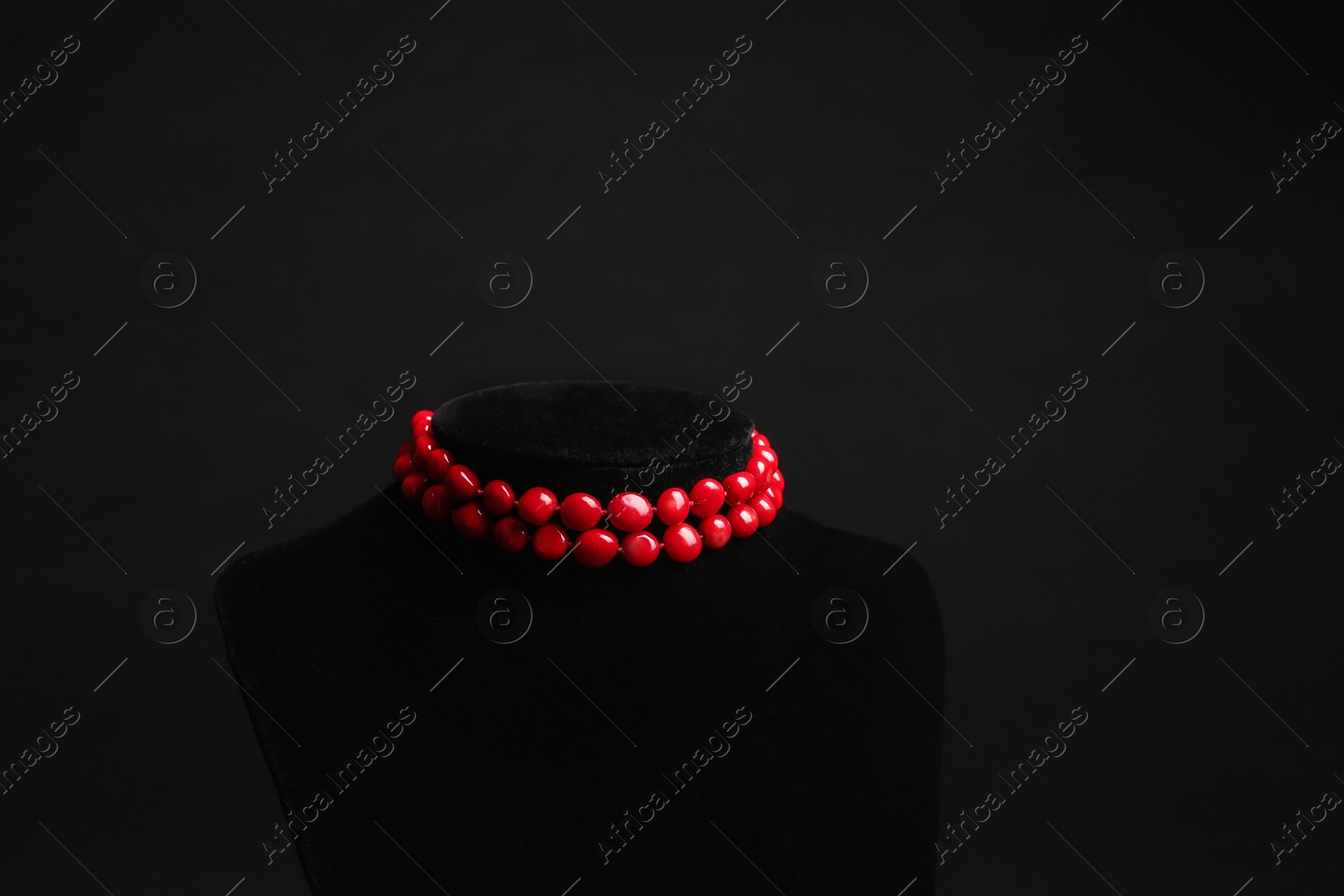 Photo of Stylish jewelry on stand against black background, space for text