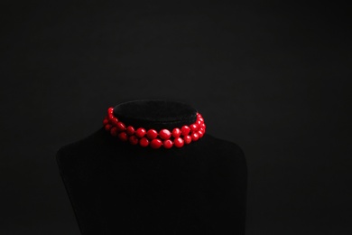 Photo of Stylish jewelry on stand against black background, space for text