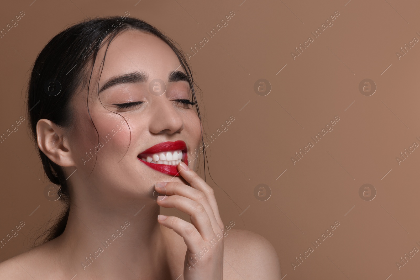 Photo of Portrait of smiling woman on brown background, closeup. Space for text