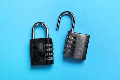 Photo of Steel combination padlocks on light blue background, top view