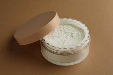 Rice loose face powder on brown background. Makeup product