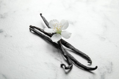 Aromatic vanilla sticks and flower on marble background