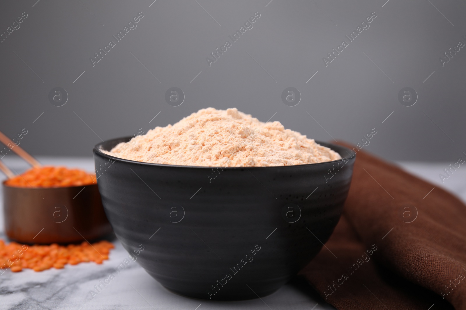 Photo of Lentil flour on white marble table, closeup