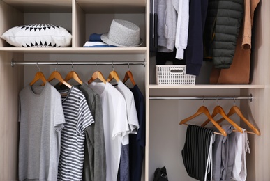 Photo of Stylish clothes and home stuff in large wardrobe closet