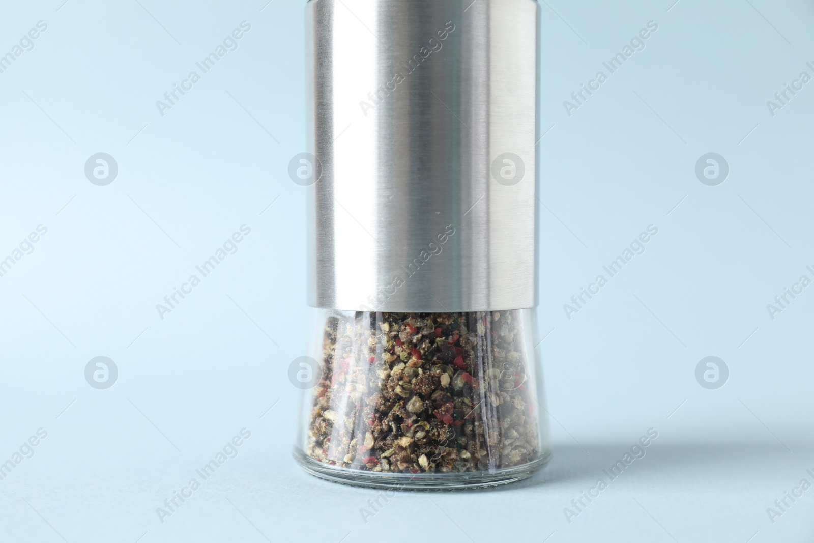 Photo of One pepper shaker on light background, closeup