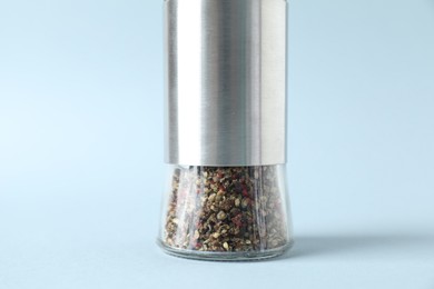 Photo of One pepper shaker on light background, closeup