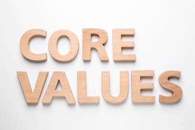 Photo of Phrase CORE VALUES made of wooden letters on white background, top view