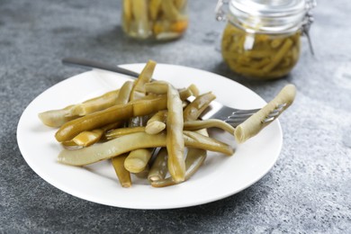 Photo of Canned green beans on grey table, closeup