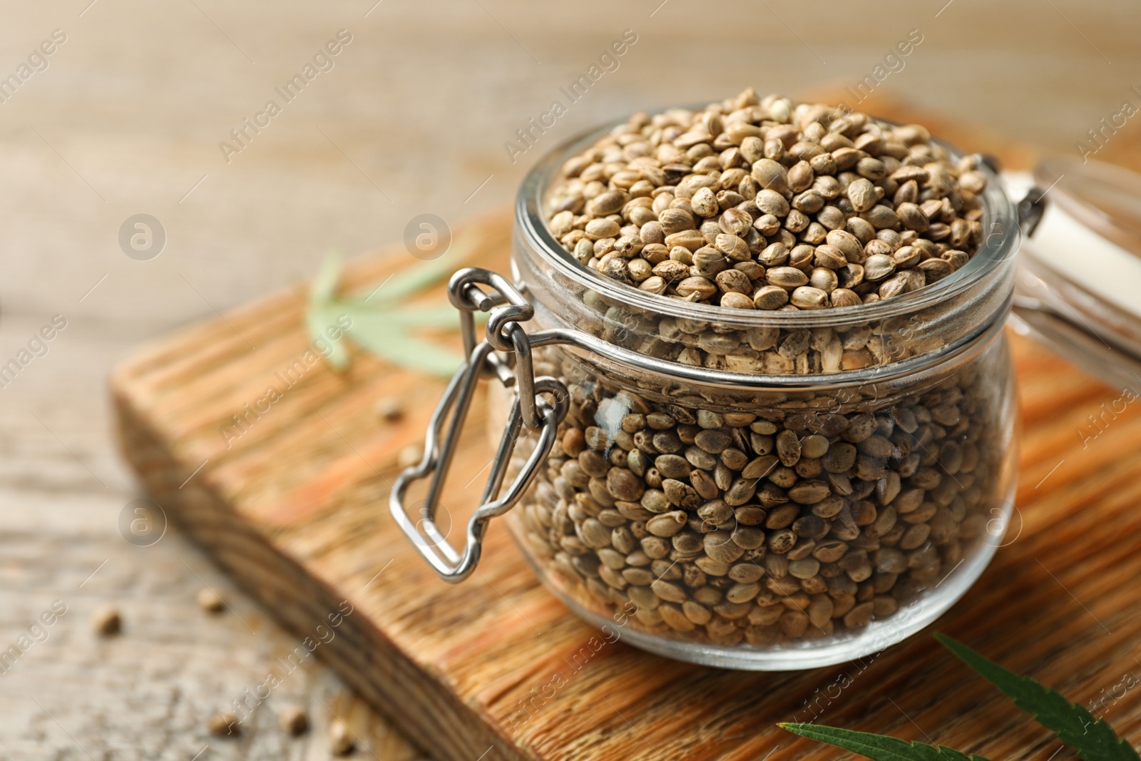 Photo of Organic hemp seeds in jar on wooden table