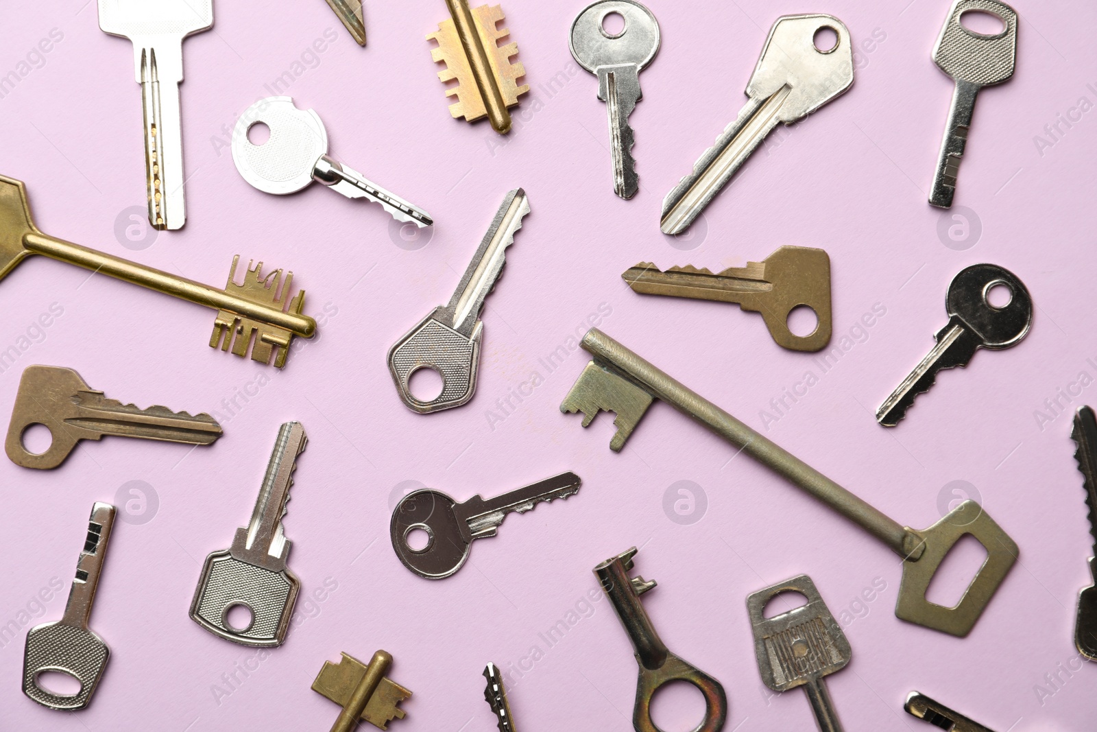 Photo of Steel keys on pink background, flat lay. Safety concept