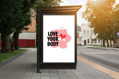 Image of Signboard with orange outline of woman figure, hearts and phrase Love Your Body on city street