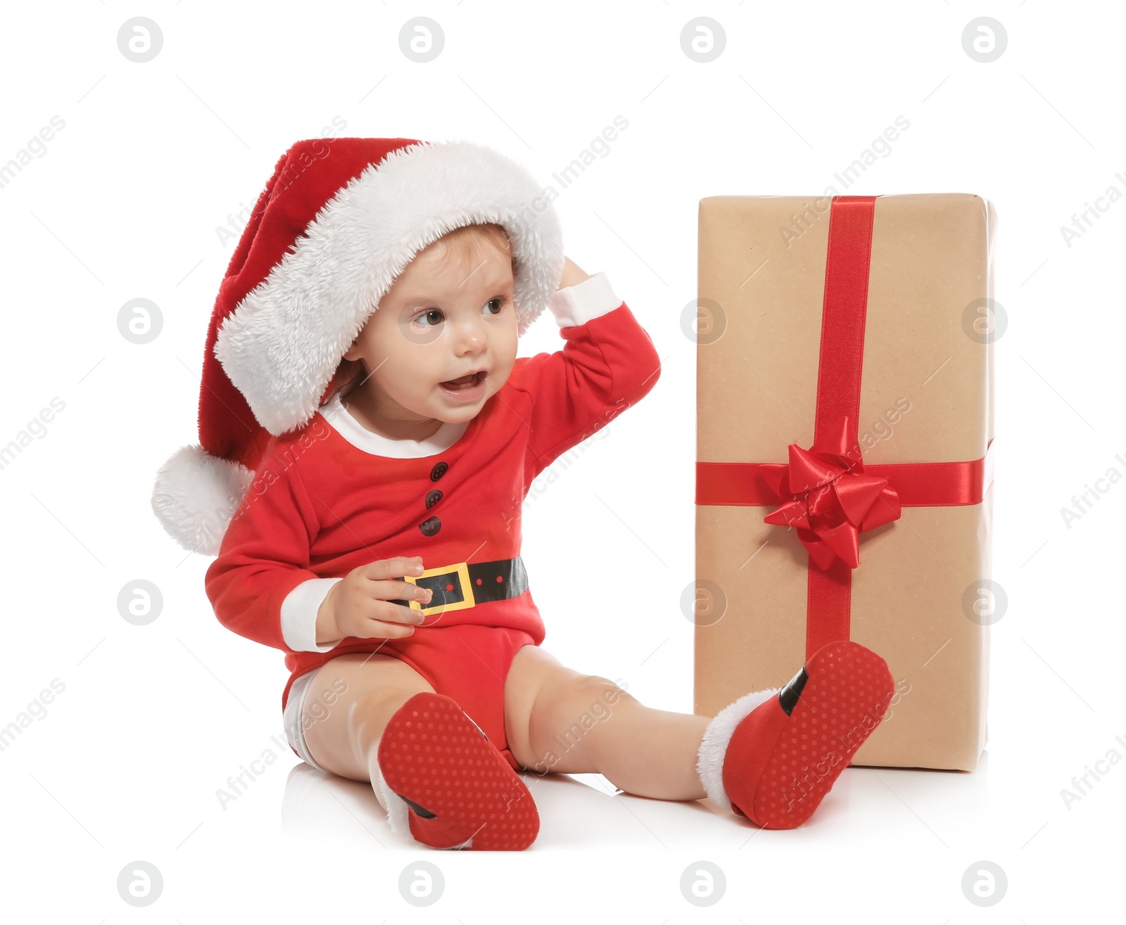 Photo of Cute little baby in Christmas costume and gift on white background