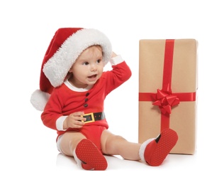 Cute little baby in Christmas costume and gift on white background