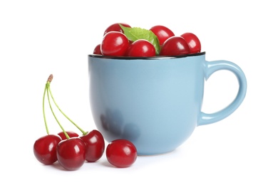 Light blue cup of delicious ripe sweet cherries on white background