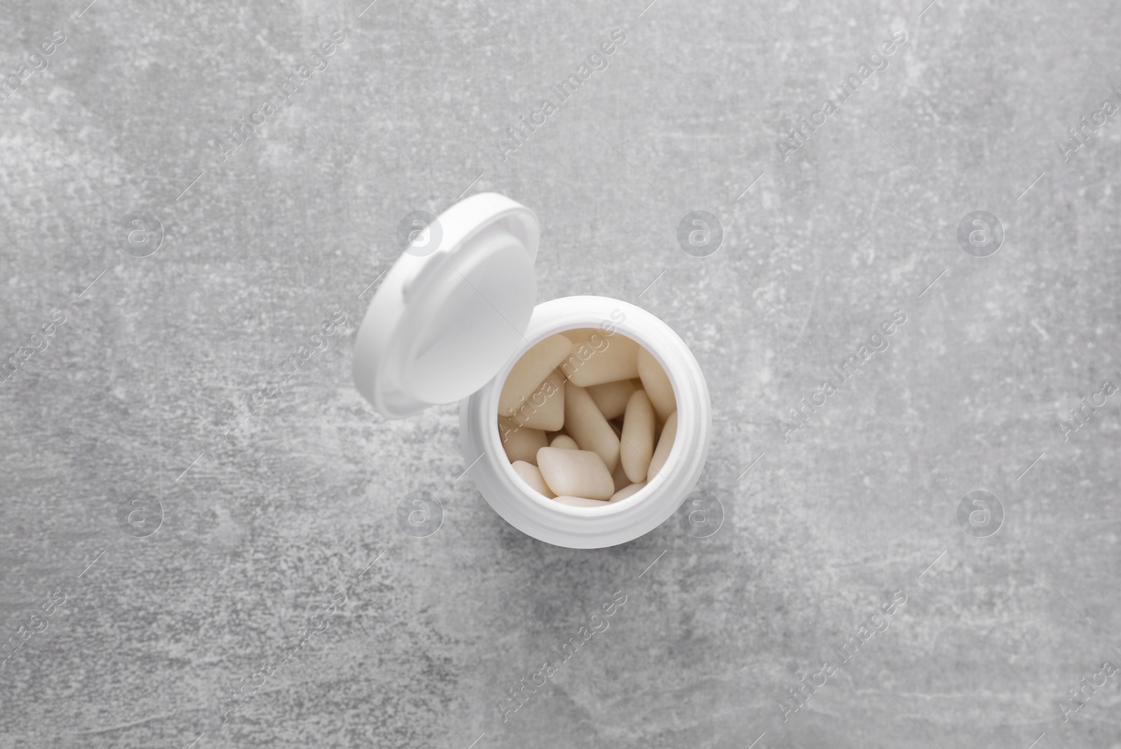 Photo of Jar with chewing gums on light grey table