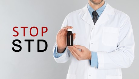 Image of STOP STD. Doctor with medicament on light grey background, closeup